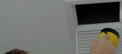 HVAC technician inspecting air duct