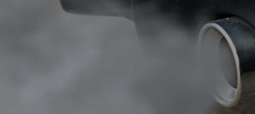 Close up of a car exhaust pipe blowing out smoke