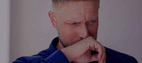 Man covering his face because his HVAC smells weird