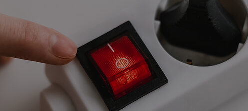 Someone turning on a power strip surge protector