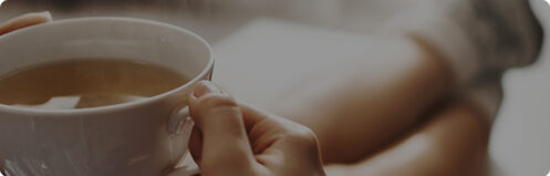 Woman relaxing in fuzzy socks holding a mug of hot coffee