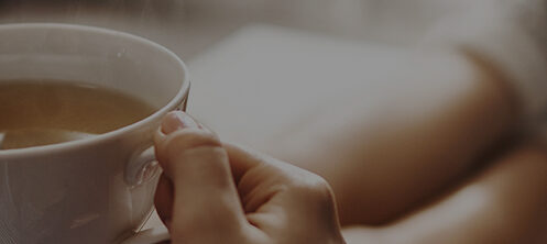 Woman relaxing in fuzzy socks holding a mug of hot coffee