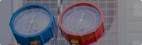 Technician checking gauges while performing HVAC maintenance