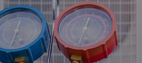 Technician checking gauges while performing HVAC maintenance
