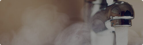 Steaming hot water coming out of a faucet