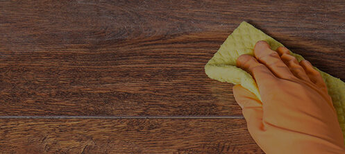 Dusty table being cleaned to prevent allergies in Sarasota FL