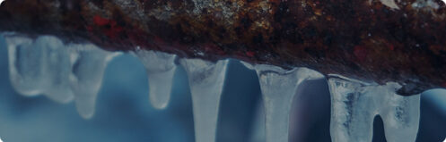 Frozen outdoor pipe with icicles hanging down
